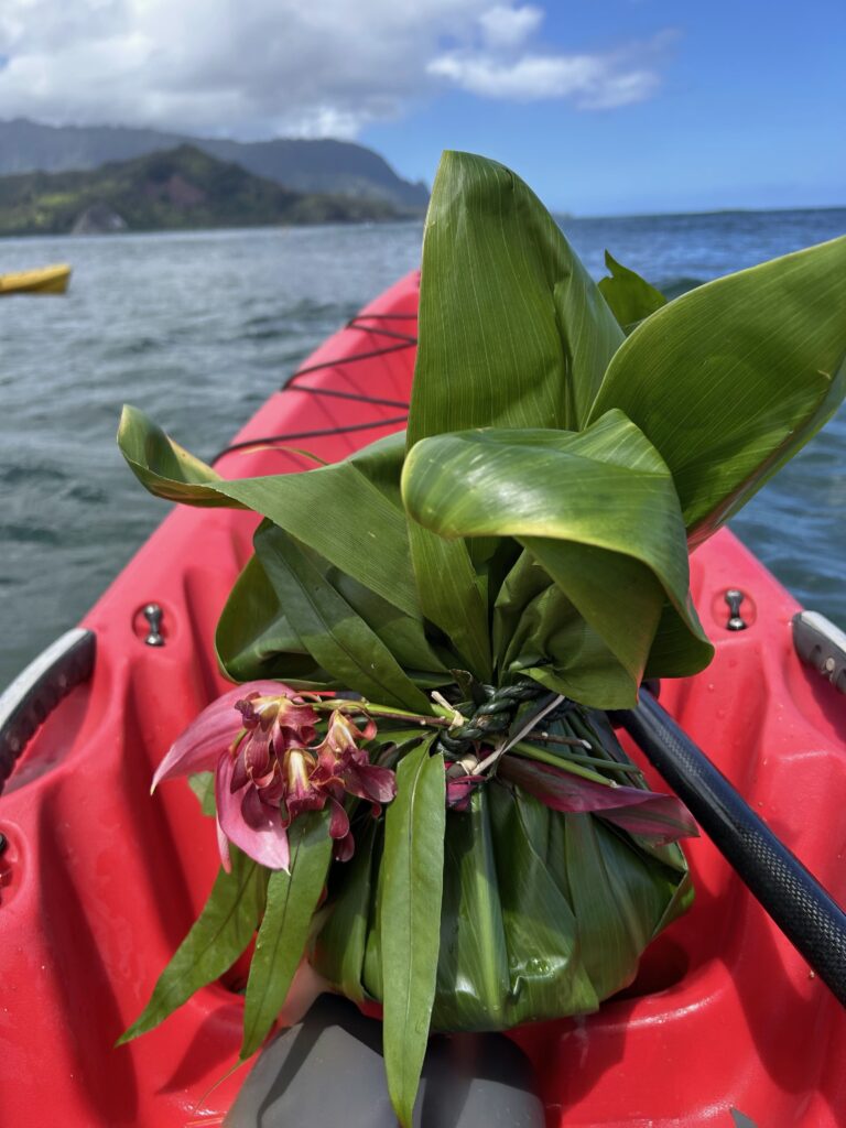 Ti-leaf bundle with burgundy flowers on a kayak