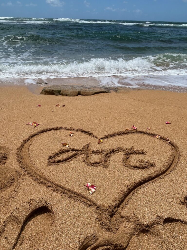 The name "Art" in a heart written in the sand on a beach